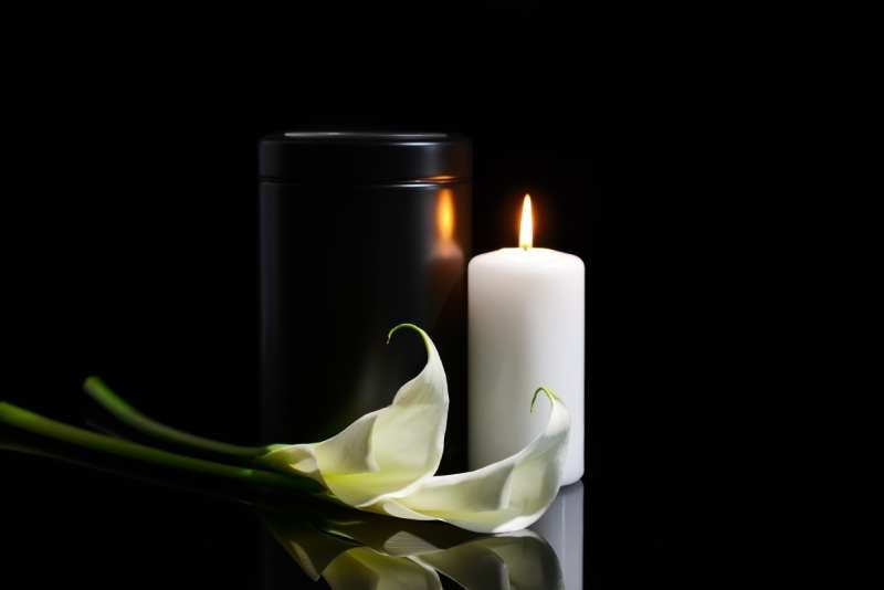 mortuary-urn-burning-candle-flowers-dark-background